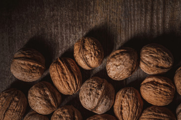 top view of walnuts arranged on wooden surface