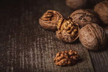 close up view of shelled and whole walnuts on wooden tabletop