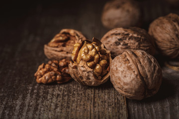 close up view of shelled and whole walnuts on wooden tabletop