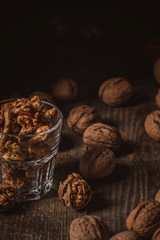 close up view of shelled walnuts in glass on wooden surface