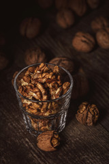 close up view of shelled walnuts in glass on wooden surface
