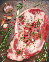 Fresh meat. Raw lamb shoulder ready for baking with garlic, rosemary, juniper, pepper and salt....