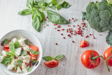 Composition Greek salad with fresh vegetables on a wooden background, feta cheese and basil. Love for the concept of healthy raw and diet food. appetizing.