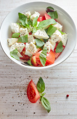 Composition Greek salad with fresh vegetables on a wooden background, feta cheese and basil. Love for the concept of healthy raw and diet food. appetizing.