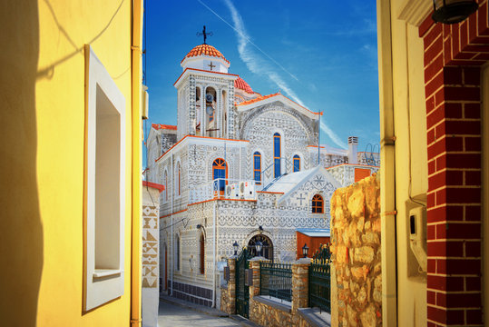    Mediterranean Greek Island Chios: Beautiful traditional ornamented church Pyrgi town with yellow colored walls of greek house buildings 