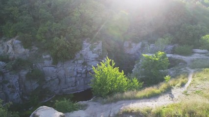 Aerial shot of a narrow river moving between high rocky banks in summer