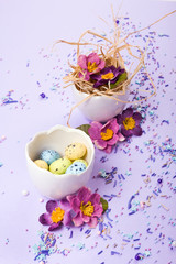 Easter decor in pastel colors. Easter eggs, candy, sweets, flowers and eggshells.