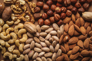 flat lay with tasty nuts arrangement on brown background
