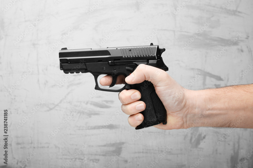 Wall mural Firearms for self-defense. Black pistol in male hand.