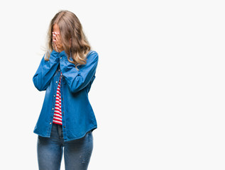 Beautiful young blonde woman over isolated background with sad expression covering face with hands while crying. Depression concept.