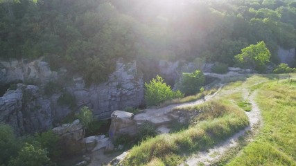 Aerial shot of a snaky river rushing between high rocky banks in summer