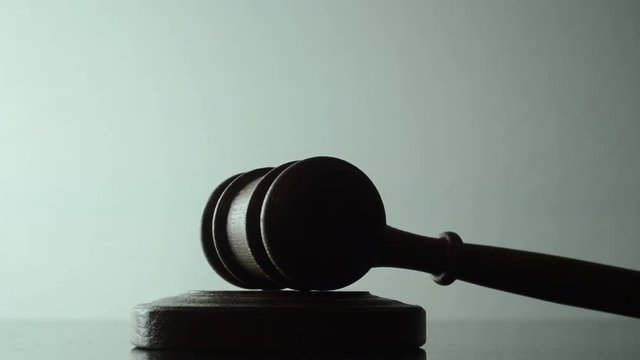Judge woman strikes with a hammer on the stand, light background, close-up 3
