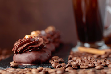  Chocolate dessert with hazelnut and coffee with cream on a wooden table.