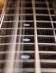 Close up of a bass guitar string and fingerboard with strings vibrating