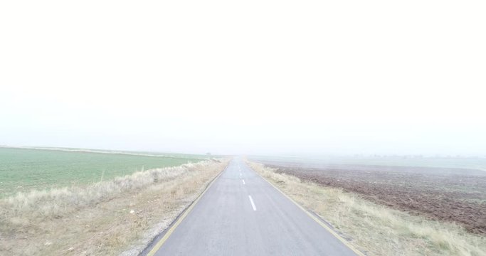 4K Aerial footage of a lonely misty road. Empty Road