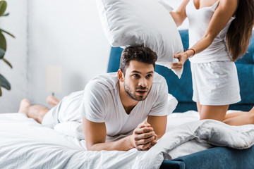 Obraz premium handsome exhausted young man resting in bed after pillow fight