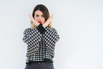 Young woman wearing casual sweater over isolated background Rejection expression crossing arms doing negative sign, angry face
