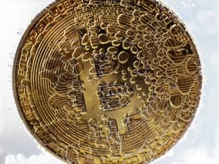 Golden bitcoin with bubbles in the water