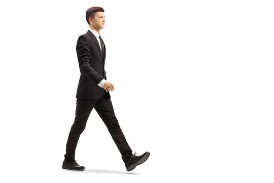Young handsome man in a black suit walking