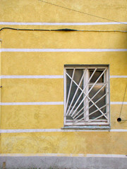 Painted yellow wall of a building with window - 238744717