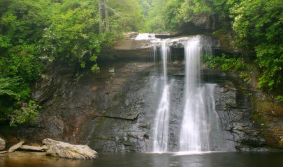 Waterfall and boulder in lush green forest, North Carolina