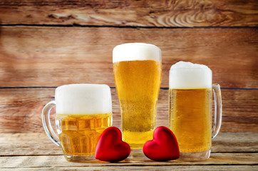Glass of cold light beer with heart on a wood background for Valentine's day
