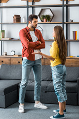 boyfriend and girlfriend standing and arguing in living room