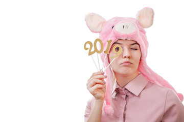 young girl in a pig costume holding in her hands the numbers 2019, looks in, isolated on white background