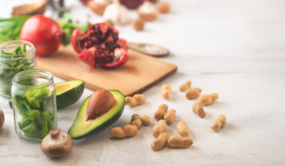 Cuisine, background of vegan food, avocado, pomegranate, green beans mushrooms, broccoli mushrooms, onions, nuts, greens. Clean and healthy food, detox, sports and diet on a white background