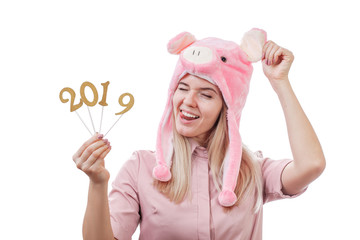 funny girl in a pig hat, make a face, shows tongue, shows figures 2019. New Year. Isolated on white background. Copy space.