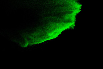 Green sand explosion isolated on black background. Abstract sand cloud. Green sand splash against ...