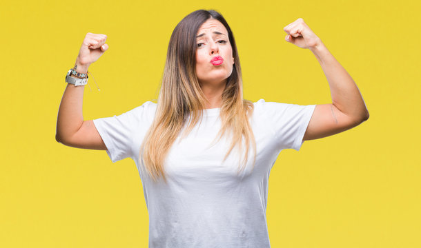 Young beautiful woman casual white t-shirt over isolated background showing arms muscles smiling proud. Fitness concept.