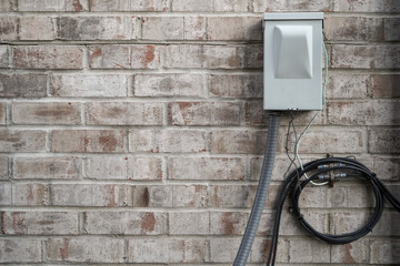 A cable junction box on a white brick house