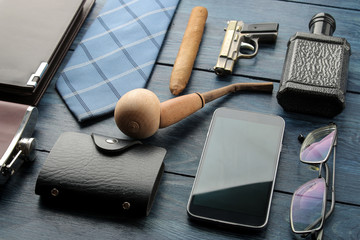 Men's Accessories. men's style. smartphone, business card holder, perfume, smoking pipe, purse on a blue wooden background.