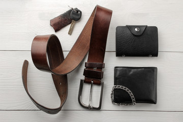 Men's Accessories. men's style. Belt, wallet, business card holder, keys on a white wooden...