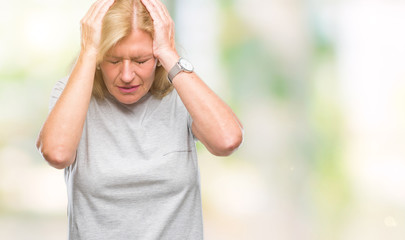 Middle age blonde woman over isolated background suffering from headache desperate and stressed because pain and migraine. Hands on head.