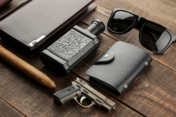 Men's Accessories. men's style. Cigar, perfume, wallet, glasses, business card holder, headphones on a brown wooden background.