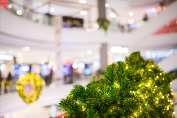 Green christmas tree with blurry department store
