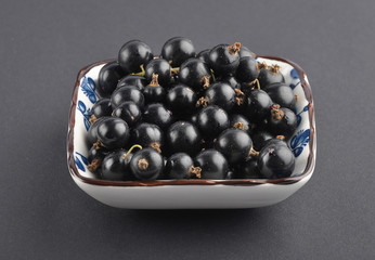 Schwarze Johannisbeeren in Schale auf schwarz