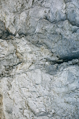 Chapped desert ground texture. White grey sand with stone background.