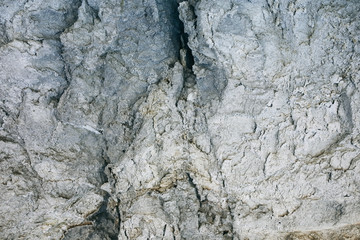 Chapped desert ground texture. White grey sand with stone background.