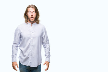Fototapeta premium Young handsome man with long hair over isolated background afraid and shocked with surprise expression, fear and excited face.