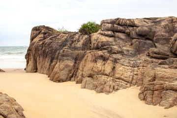 Boulders on the sandy beach by the sea