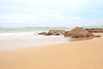 Fototapeta na wymiar Boulders on the sandy beach by the sea