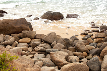 Boulders on the sandy beach by the sea