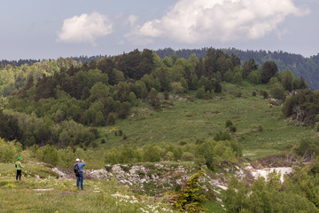 Naklejka na ściany i meble Tourists visit the routes on the mountain, summer.