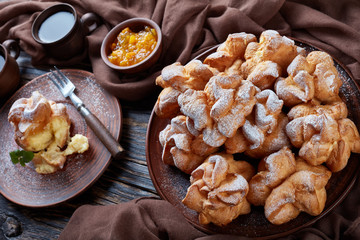 Profiterole topped with powdered sugar, dark style