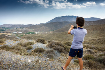 Boy photographing landscape
