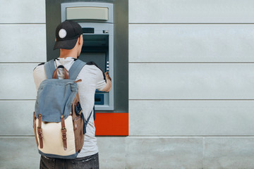 The tourist withdraws money from the ATM for further travel. Finance, credit card, withdrawal of...