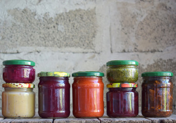 Variety of preserved food in glass jars - pickles, jam, marmalade, sauces, ketchup. Preserving vegetables and fruits. Fermented food. Autumn canning. Conservation of harvest
